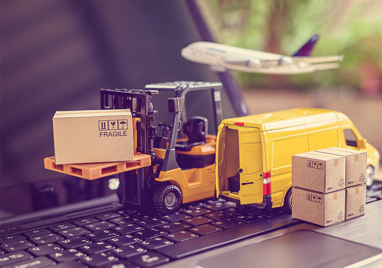 Boxed Equipment on forklift besides a moving van with airplane overhead